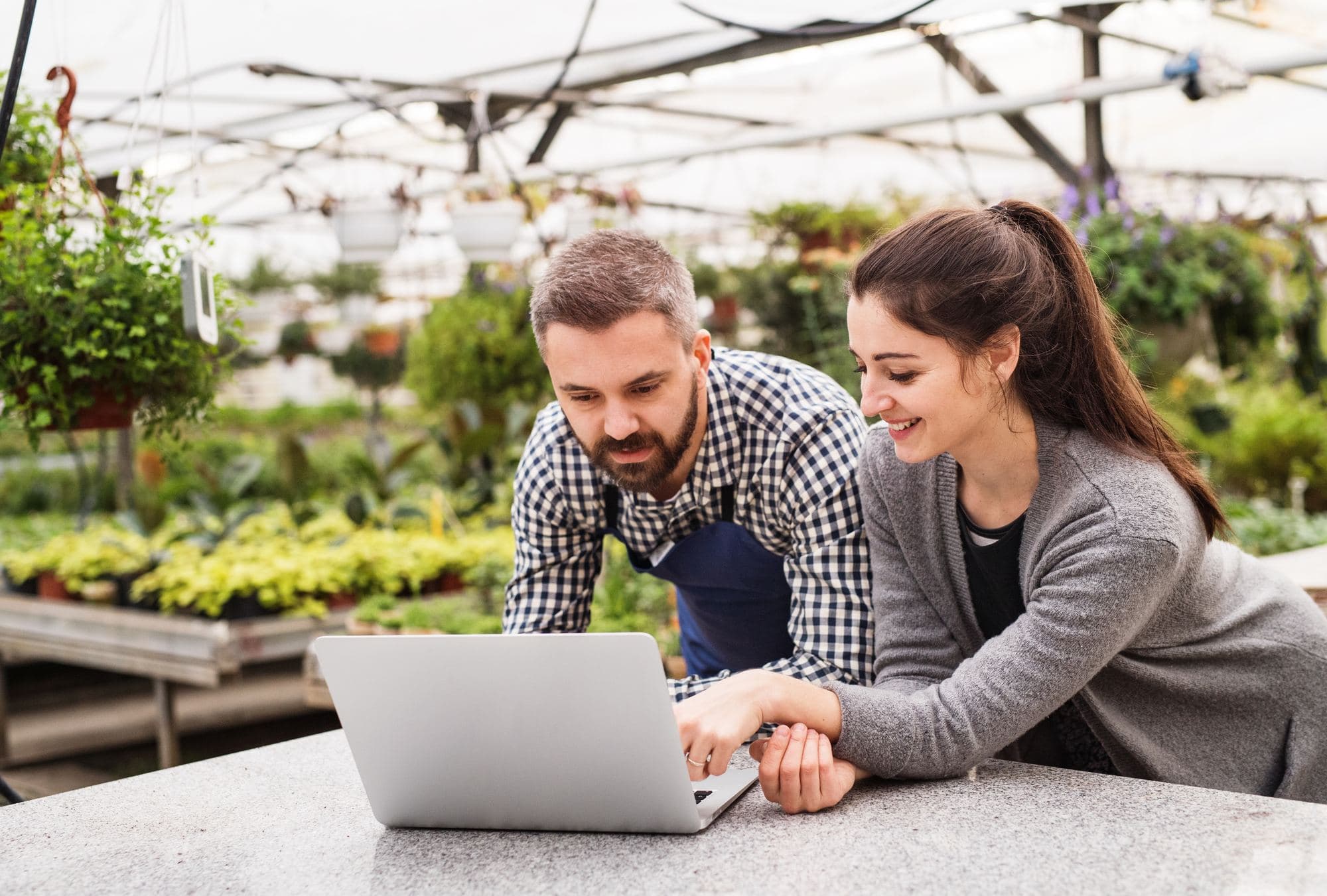 Two people going through the books at a garden center